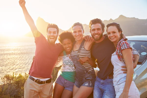 Grupp vänner står med bil vid solnedgången — Stockfoto