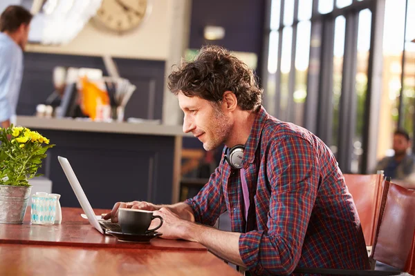 Homme travaillant sur ordinateur au café — Photo