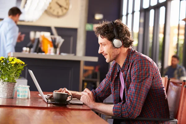 Man working on computer at coffee shop — Stock Photo, Image