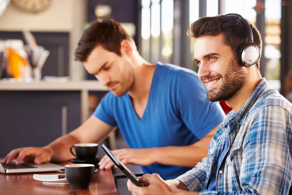 Männer, die in einem Café an Computern arbeiten — Stockfoto