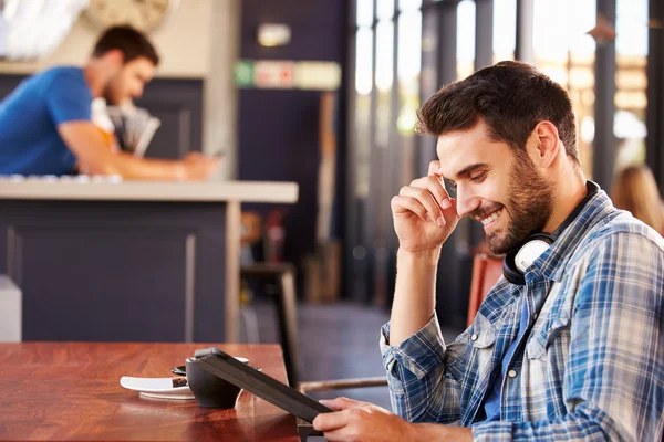 Uomo che utilizza tablet digitale in una caffetteria — Foto Stock