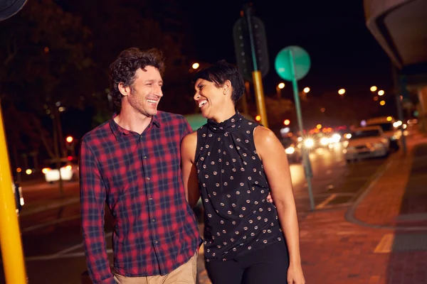 Couple walking through town at night — Stock Photo, Image