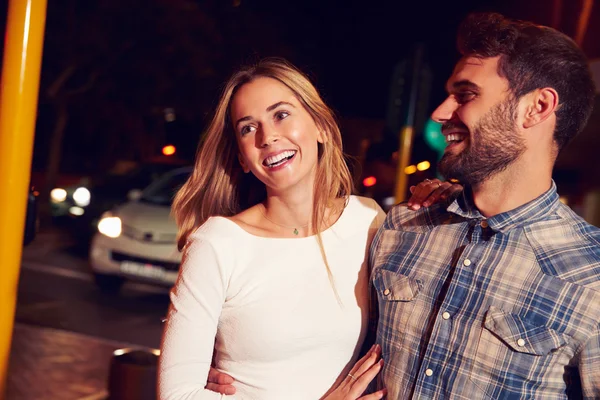 Pareja caminando por la ciudad por la noche — Foto de Stock