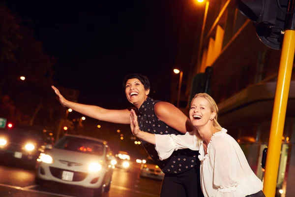 Amigos llamando al taxi por la noche —  Fotos de Stock