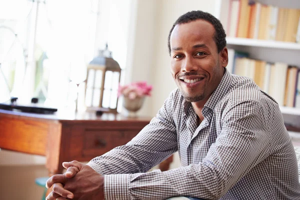 Smiling man sitting in a room — Stock Photo, Image