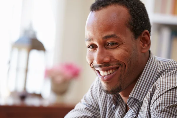 Smiling man sitting in a room — Stock Photo, Image