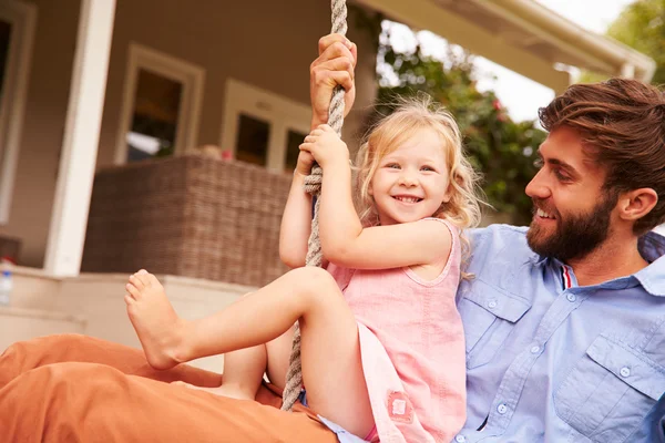 Pappa spelar med dotter på en rep gunga — Stockfoto