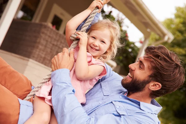 Pappa spelar med dotter på en rep gunga — Stockfoto