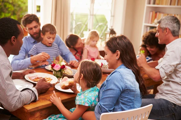 Famille et amis assis à une table à manger — Photo