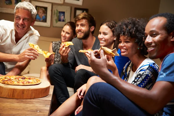 Amici che mangiano pizza a una festa in casa — Foto Stock