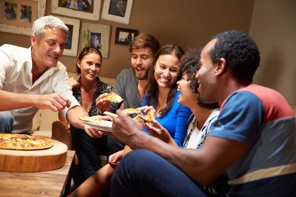 Amigos comendo pizza em uma festa em casa — Fotografia de Stock