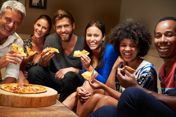 Przyjaciele jedzenie pizzy w stronę domu — Zdjęcie stockowe