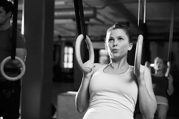 Mujer usando anillos gimnásticos en el gimnasio —  Fotos de Stock