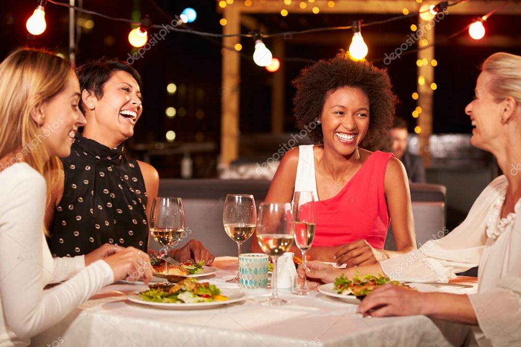 Friends eating dinner at rooftop restaurant — Stock Photo