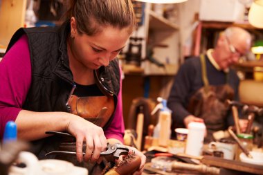 Shoemakers working in a workshop clipart