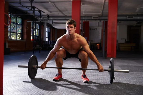 Hombre en el gimnasio preparándose para levantar pesas — Foto de Stock