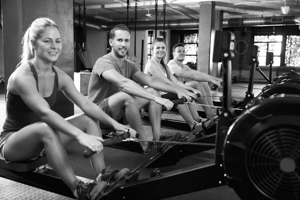 Clase de gimnasia trabajando en máquinas de remo —  Fotos de Stock