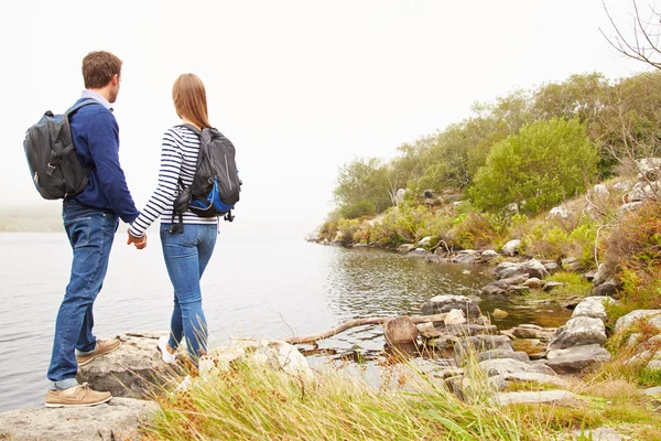 Молода пара стоїть біля озера — стокове фото