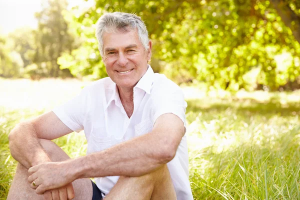 Homme âgé assis sur l'herbe — Photo