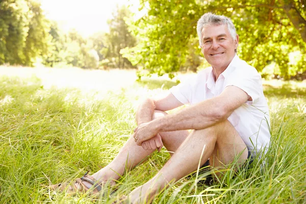 Homme âgé assis sur l'herbe — Photo