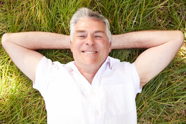 Homme âgé allongé sur l'herbe — Photo