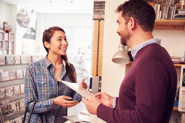 Cliente femenino siendo atendido en el mostrador — Foto de Stock