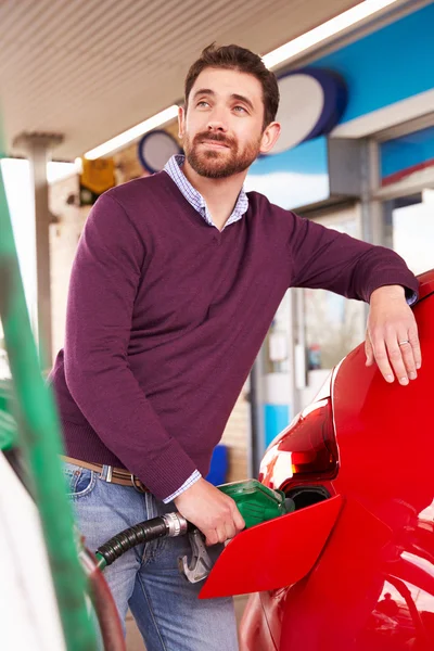 Homem reabastecendo um carro em um posto de gasolina — Fotografia de Stock