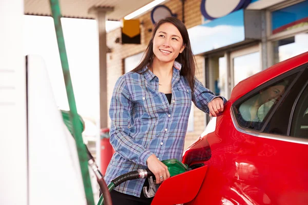 Mulher reabastecendo um carro em um posto de gasolina — Fotografia de Stock
