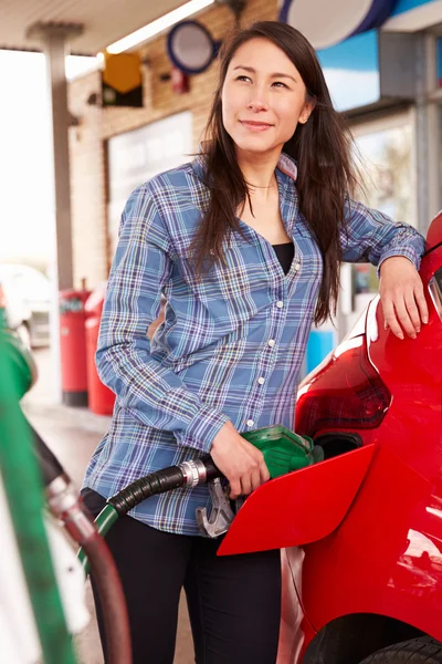 Mulher reabastecendo um carro em um posto de gasolina — Fotografia de Stock