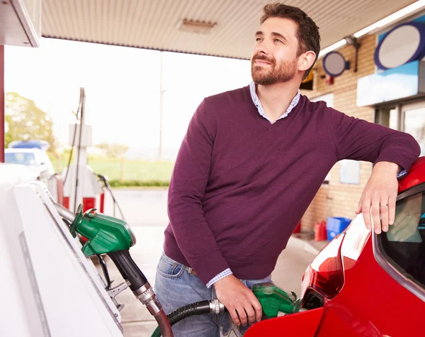 Man in een auto bij een benzinepost tanken — Stockfoto