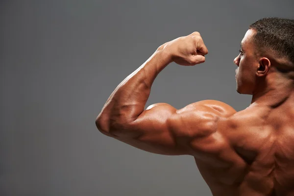 Male bodybuilder flexing bicep — Stock Photo, Image