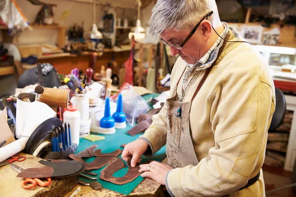 Shoemaker cutting and gluing leather — Stock Photo, Image