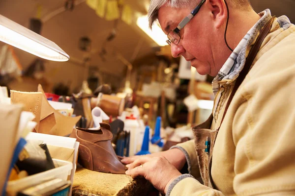 Senior skomakare arbetar med läder — Stockfoto