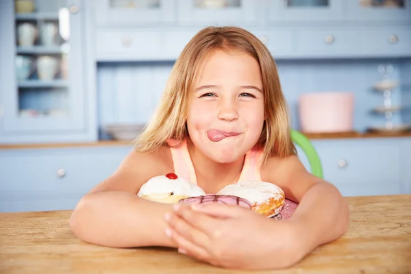 Dívka při pohledu na desku sladké dorty — Stock fotografie