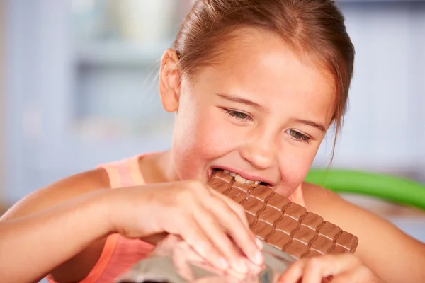 Menina comer bar de chocolate — Fotografia de Stock