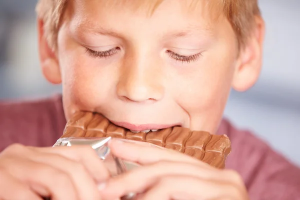 Garçon manger une barre de chocolat — Photo