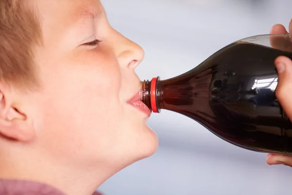 Мальчик пьет соду из бутылки — стоковое фото