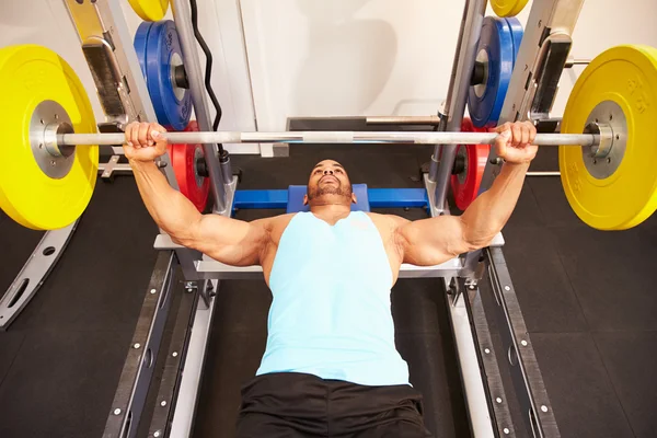 Man pressing weights at a gym — Stock Photo, Image