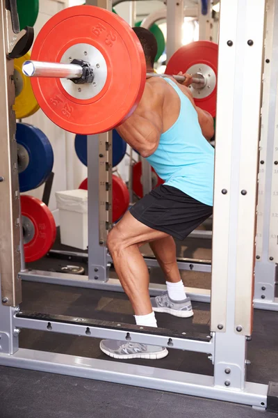 Muž ve vzpírání barbells v tělocvičně — Stock fotografie