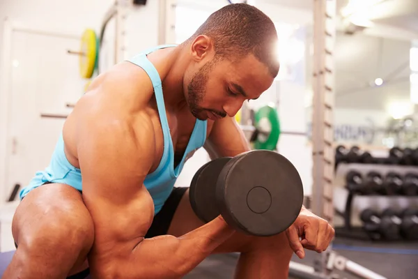 Hombre haciendo ejercicio con pesas en un gimnasio — Foto de Stock