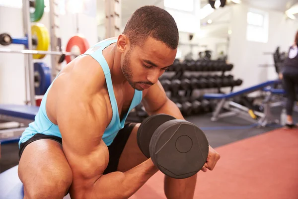 Man exercising with dumbbells at a gym — Stock Photo, Image