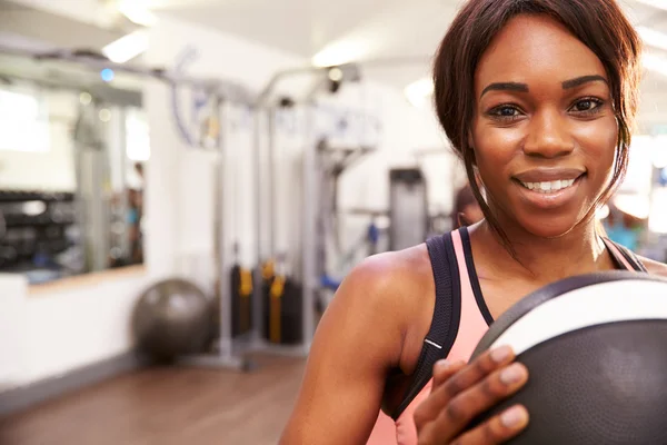 Mujer sosteniendo una pelota de medicina en un gimnasio —  Fotos de Stock