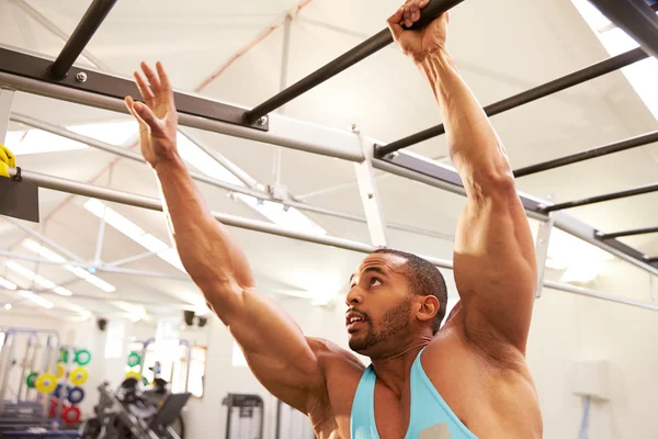 Hombre musculoso haciendo ejercicio en un gimnasio — Foto de Stock