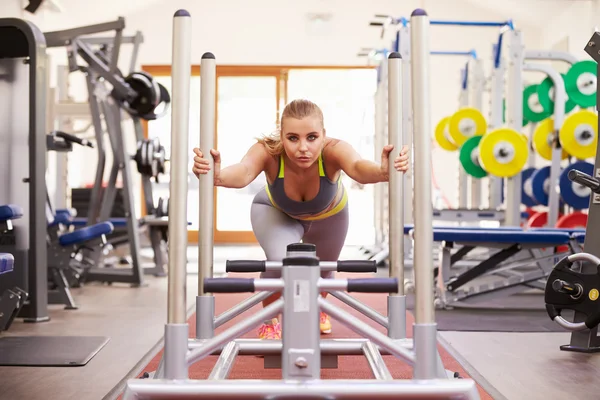 Vrouw met behulp van apparatuur bij een sportschool — Stockfoto