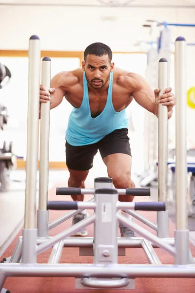 Мускулистый мужчина тренируется в спортзале — стоковое фото