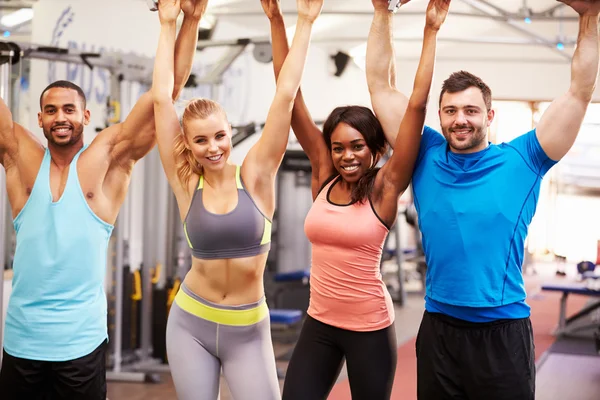 Group of people with arms in the air at a gym Stock Photo