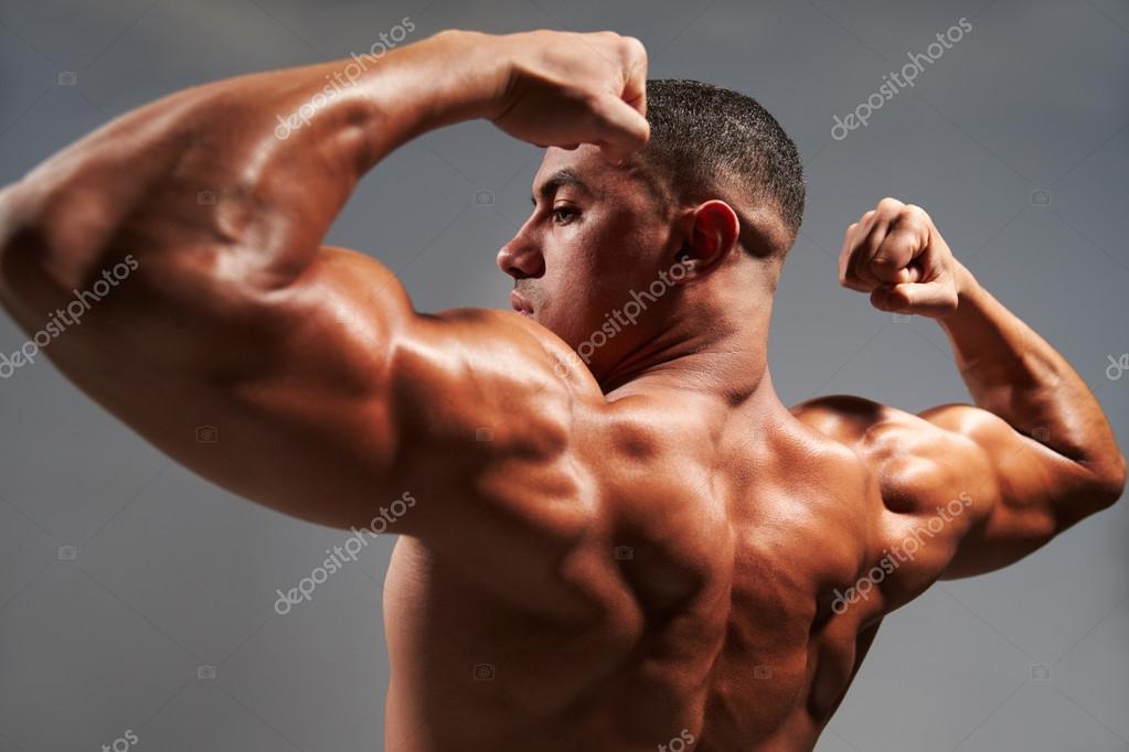 Male Bodybuilder Flexing Bicep, Back View With Copy Space