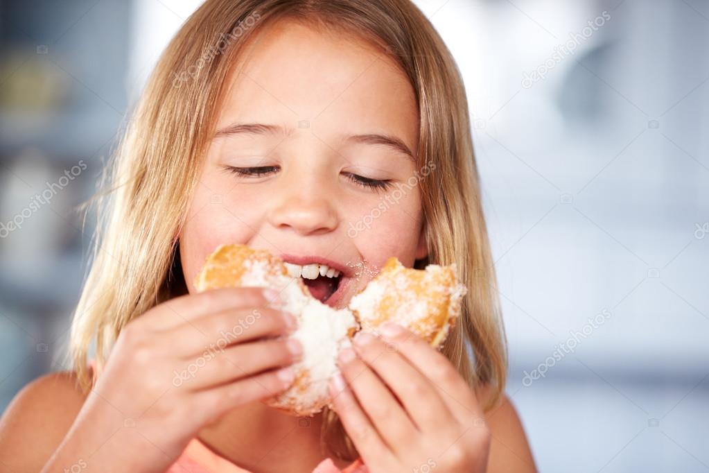 Girl Sitting Eating Sugary Donut — Stock Photo © monkeybusiness 98226988