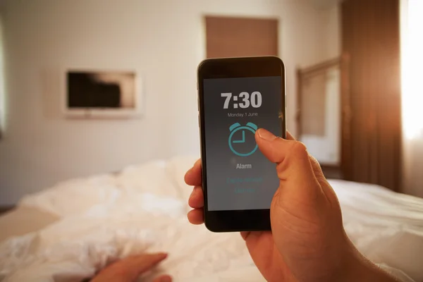 Ember az ágyban telefon ébresztés kikapcsolása — Stock Fotó