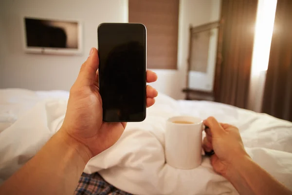 Yatakta hareket eden telefon arayan kişi — Stok fotoğraf